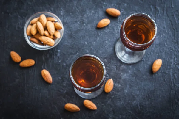 İtalyan likörü Amaretto badem siyah taş arka planda, kopya alanı ile