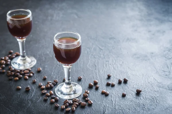 Kahve likörü kahve çekirdekleri rustik siyah taş arka plan kopya alanı ile. Ev yapımı kahve likörü.