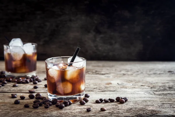 Siyah Rus kokteyl votka ve kahve likörü ile. Ev yapımı alkollü ayyaş siyah Rus iç ahşap zemin kopya alanı üzerine kahve çekirdekleri ile.