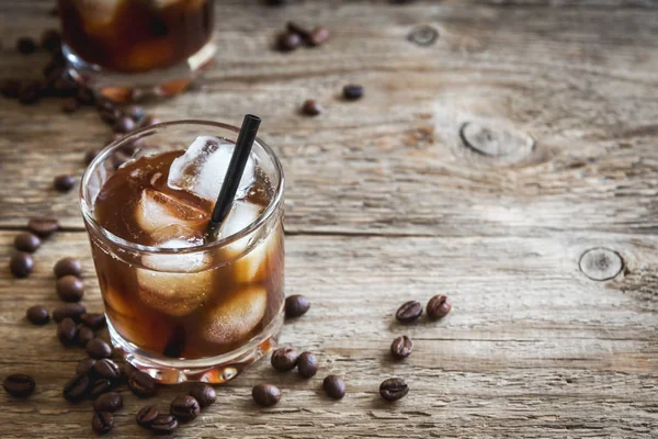 Siyah Rus kokteyl votka ve kahve likörü ile. Ev yapımı alkollü ayyaş siyah Rus iç ahşap zemin kopya alanı üzerine kahve çekirdekleri ile.