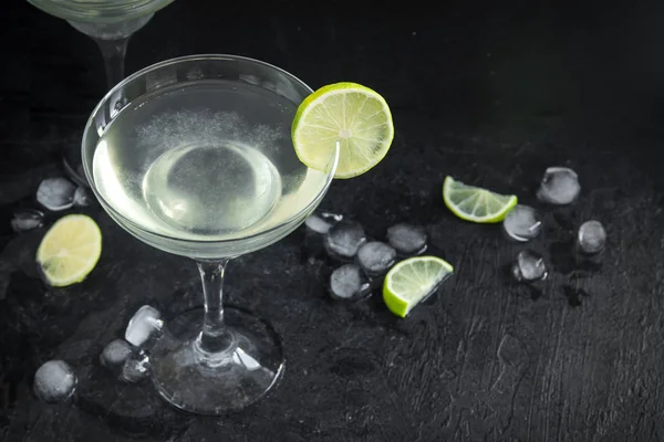 玛格丽塔鸡尾酒用石灰和冰在黑石桌上复制空间 经典玛格丽塔鸡尾酒 — 图库照片