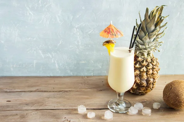 Pina Colada kokteyli ananas ve hindistancevizi üzerinde ahşap arka plan, uzay kopyalayın. Yaz tropikal lezzetli kokteyl.