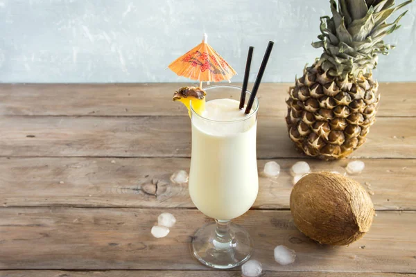 Pina Colada kokteyli ananas ve hindistancevizi üzerinde ahşap arka plan, uzay kopyalayın. Yaz tropikal lezzetli kokteyl.