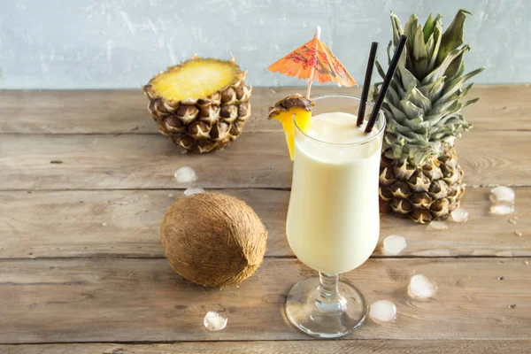 Pina Colada kokteyli ananas ve hindistancevizi üzerinde ahşap arka plan, uzay kopyalayın. Yaz tropikal lezzetli kokteyl.