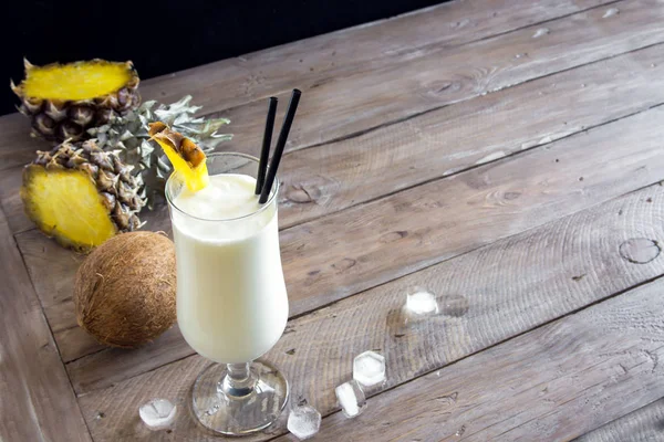 Pina Colada kokteyli ananas ve hindistancevizi üzerinde ahşap arka plan, uzay kopyalayın. Yaz tropikal lezzetli kokteyl.