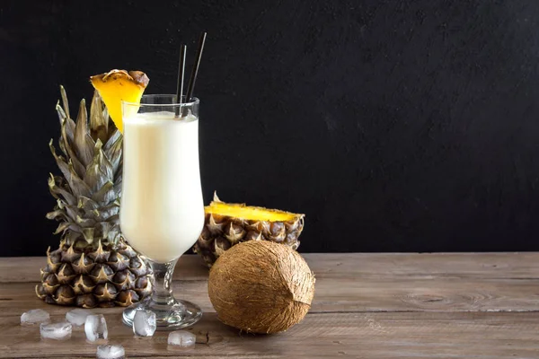 Pina Colada kokteyli ananas ve hindistancevizi üzerinde ahşap arka plan, uzay kopyalayın. Yaz tropikal lezzetli kokteyl.