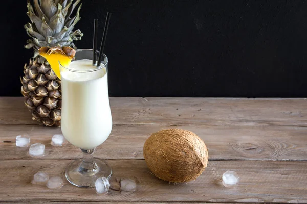 Pina Colada kokteyli ananas ve hindistancevizi üzerinde ahşap arka plan, uzay kopyalayın. Yaz tropikal lezzetli kokteyl.