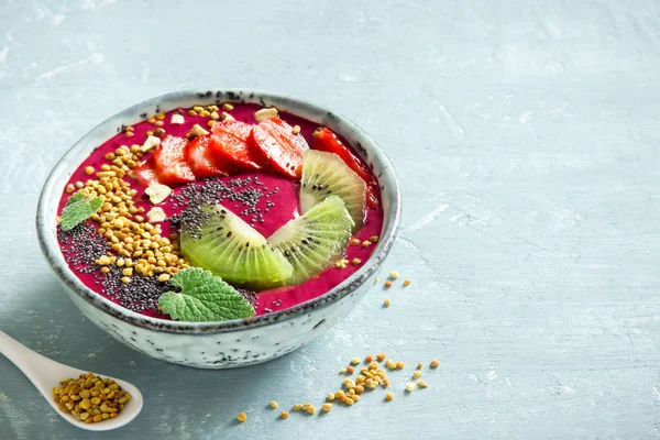 Acai smoothie kaseyle chia tohum, meyve, meyve (çilek) ve arı polen sağlıklı vegan vejetaryen diyet çiğ kahvaltı için. Güler yüzlü kase beyaz zemin üzerine kahvaltı, alanı Kopyala.