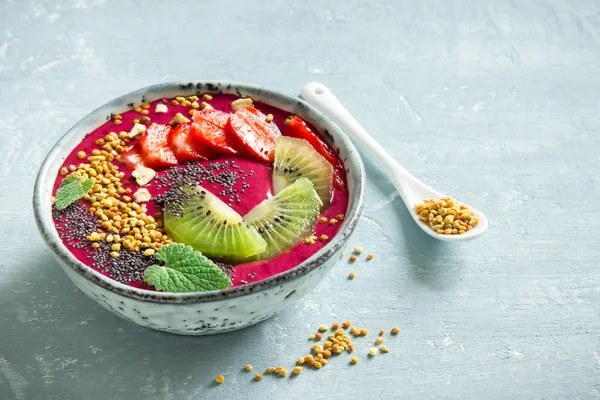 Acai smoothie kaseyle chia tohum, meyve, meyve (çilek) ve arı polen sağlıklı vegan vejetaryen diyet çiğ kahvaltı için. Güler yüzlü kase beyaz zemin üzerine kahvaltı, alanı Kopyala.