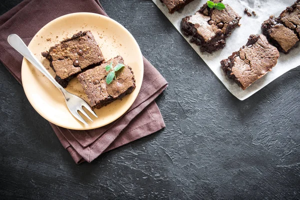 Çift çikolatalı kek. Ev yapımı çikolata fudge kek Çikolata ve kakao tozu siyah masada.