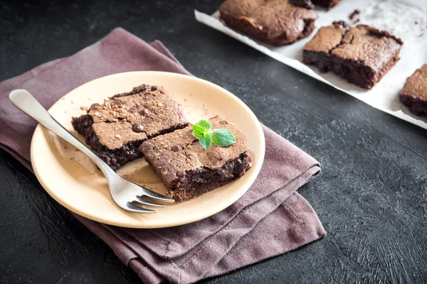 Çift çikolatalı kek. Ev yapımı çikolata fudge kek Çikolata ve kakao tozu siyah masada.