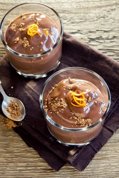 Çikolatalı mus ahşap arka plan yakın up - lezzetli ev yapımı çikolatalı puding üzerinde bardaklarda portakal lezzet ile tepesinde