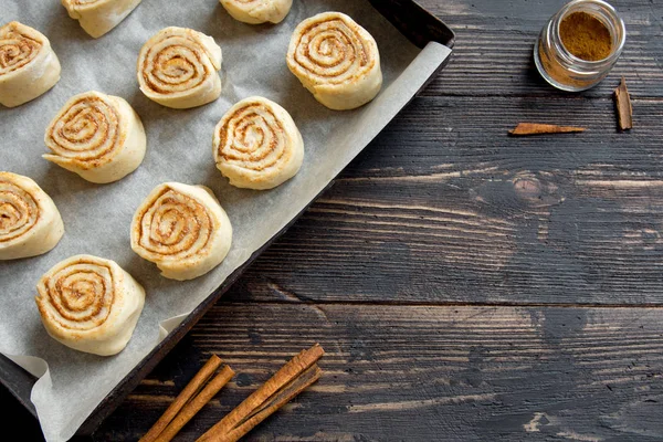 Rulo tarçın veya cinnabon, ev yapımı tarifi çiğ hamur hazırlık tatlı geleneksel tatlı çörekler pasta yemek. Uzay Gıda ingridients rulo tarçın, ahşap masa üzerinde düz lay için kopyalama.