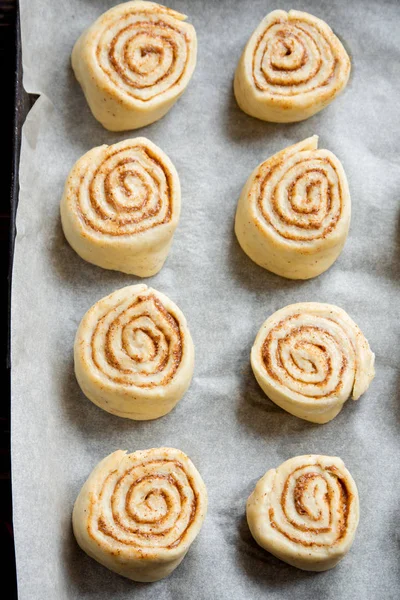 Rulo tarçın veya cinnabon, ev yapımı tarifi çiğ hamur hazırlık tatlı geleneksel tatlı çörekler pasta yemek. Gıda ingridients rulo tarçın için düz tepsi pişirme üzerinde yatıyordu.