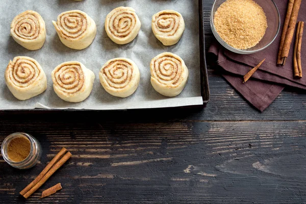 Rulo tarçın veya cinnabon, ev yapımı tarifi çiğ hamur hazırlık tatlı geleneksel tatlı çörekler pasta yemek. Uzay Gıda ingridients rulo tarçın, ahşap masa üzerinde düz lay için kopyalama.