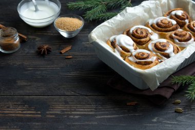 Rulo tarçın veya cinnabon Noel için. Ev yapımı geleneksel kış şenlikli tatlı çörekler pasta kopya alanı koyu ahşap zemin üzerine.