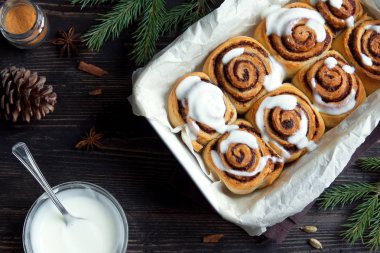Rulo tarçın veya cinnabon Noel için. Ev yapımı geleneksel kış şenlikli tatlı çörekler pasta koyu ahşap arka plan üzerinde.
