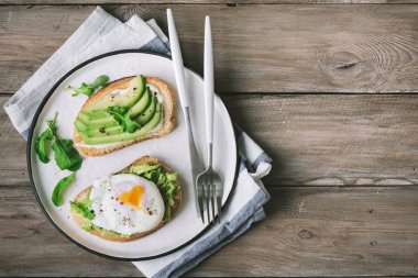 Haşlanmış yumurta - avokado sandviç avokado dilimleri ve sağlıklı kahvaltı veya aperatif, kopya alanı için roka ile kızarmış ekmek üzerinde yumurta haşlanmış.