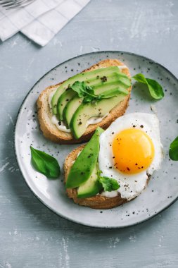 Sahanda yumurta - dilimlenmiş avokado ve sağlıklı kahvaltı veya aperatif, kızarmış ekmek üzerinde yumurta ile avokado sandviç kopyalama alanı.