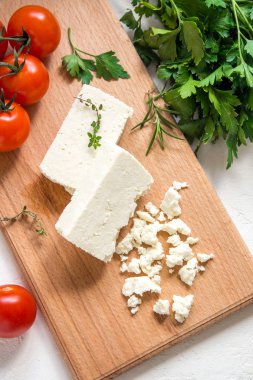 Taze Yunan beyaz peynir. Salata yemek için sağlıklı bir madde. Ufalanmış keçi beyaz peynir kesme tahtası üzerinde.