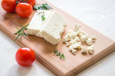 Taze Yunan beyaz peynir. Salata yemek için sağlıklı bir madde. Ufalanmış keçi beyaz peynir kesme tahtası üzerinde.