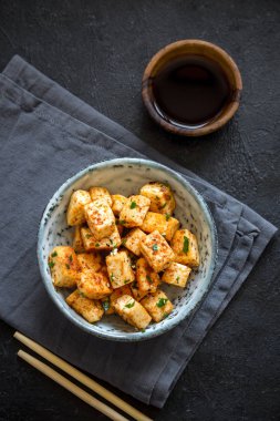 Kızarmış Tofu susam ve yeşillik ile bir kasede karıştırın. Ev yapımı sağlıklı vejetaryen Asya yemek - kızarmış tofu.