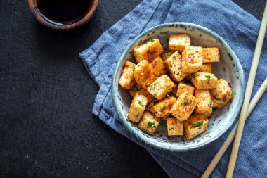 Kızarmış Tofu susam ve yeşillik ile bir kasede karıştırın. Ev yapımı sağlıklı vejetaryen Asya yemek - kızarmış tofu.