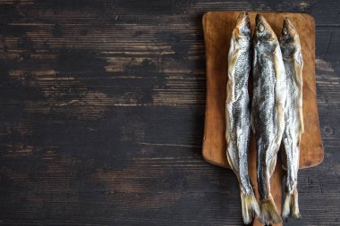 Güneş kurutulmuş balık, tuzlu smelts ahşap arka plan, üstten görünüm, kopya alanı üzerinde. Aperatif Kurutulmuş bira için smelts.