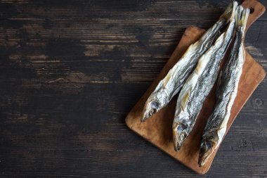 Güneş kurutulmuş balık, tuzlu smelts ahşap arka plan, üstten görünüm, kopya alanı üzerinde. Aperatif Kurutulmuş bira için smelts.