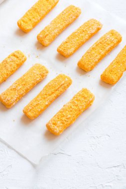 Kızarmış balık, Balık kroket kağıt ve beyaz arka plan, donmuş alanı kopyalayın. Rahatlık gıda, deniz ürünleri, balık yemek çubukları kroket.