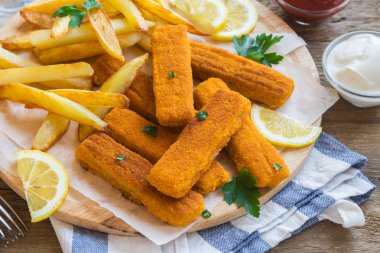 Kızarmış balık patates kızartması ile sopa. Balık kroket ahşap arka plan üzerinde. Balık köftesi ile kızarmış patates ve limon yemek hazır.