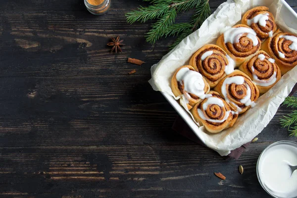 Rulo tarçın veya cinnabon Noel için. Ev yapımı geleneksel kış şenlikli tatlı çörekler pasta kopya alanı koyu ahşap zemin üzerine.