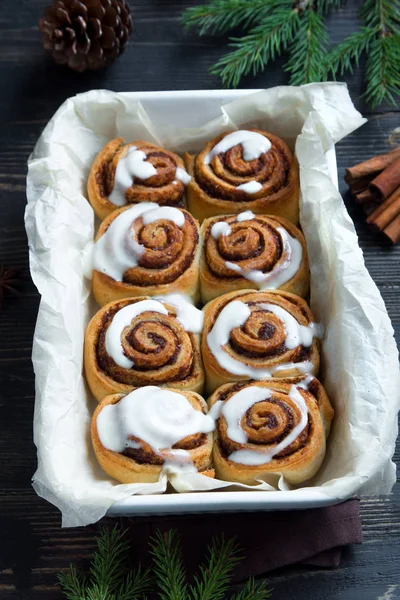 Rulo tarçın veya cinnabon Noel için. Ev yapımı geleneksel kış şenlikli tatlı çörekler pasta kopya alanı koyu ahşap zemin üzerine.