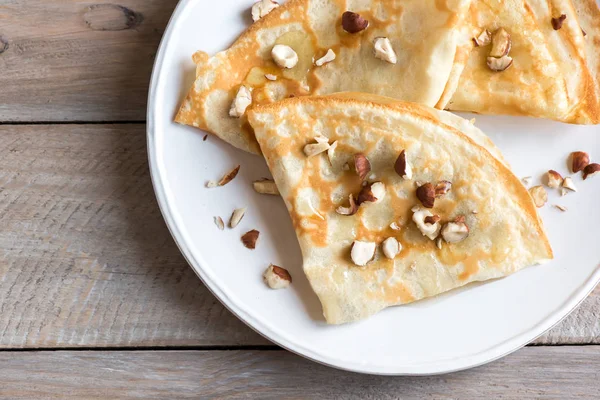 Crepes Suzette Med Honung Och Nötter Vit Platta Över Trä — Stockfoto