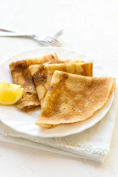 薄饼叙泽特与柠檬在白色盘上白色背景 复制空间 美味的自制薄饼早餐 — 图库照片