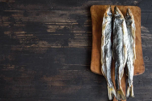 Güneş kurutulmuş balık, tuzlu smelts ahşap arka plan, üstten görünüm, kopya alanı üzerinde. Aperatif Kurutulmuş bira için smelts.