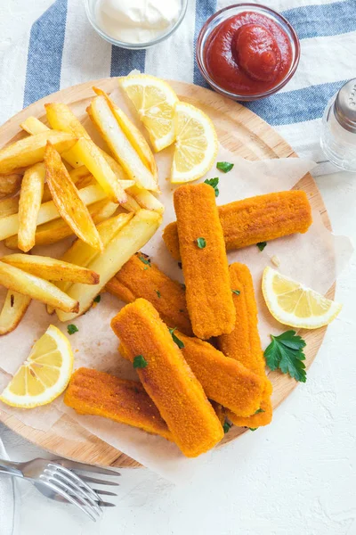 Fried Fish Sticks with French Fries. Fish Fingers. Fish Sticks with fried potato and lemon ready to eat.