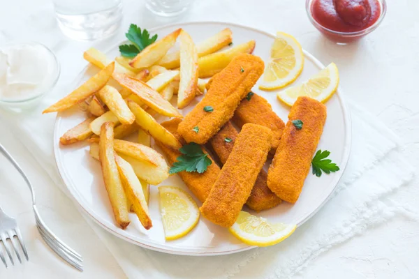 Fried Fish Sticks with French Fries. Fish Fingers. Fish Sticks with fried potato and lemon ready to eat.