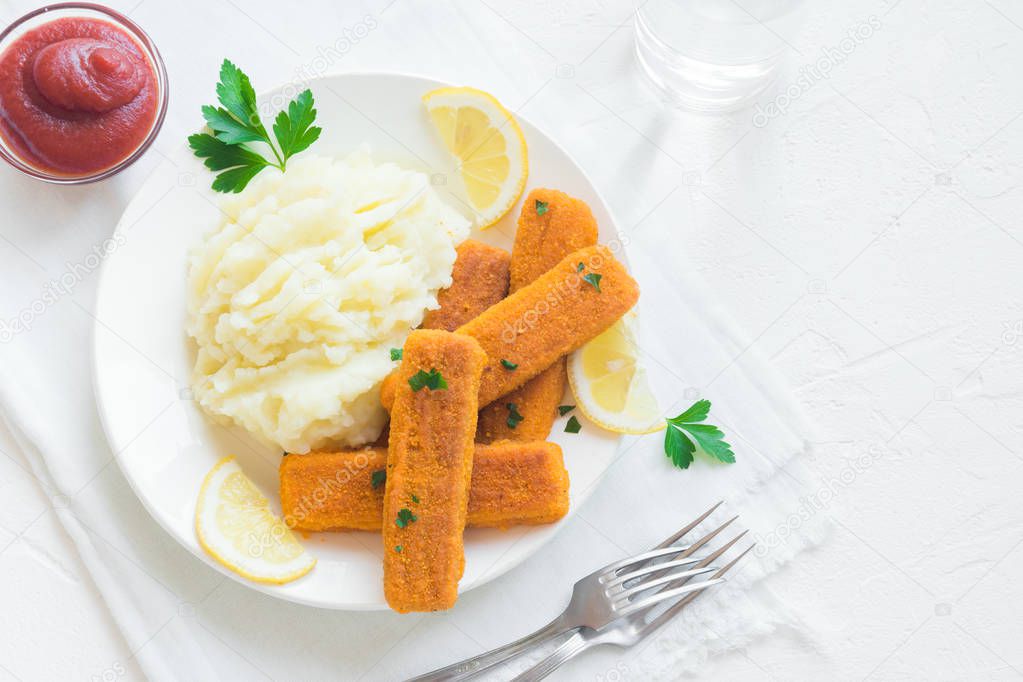 Fried fish fingers, mashed potatoes and lemon. Delicious lunch with fish sticks and vegetables, convenient seafood