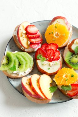 Ricotta peynirli meyve tatlı sandviç. Lezzetli sağlıklı kahvaltı tost ile krem peynir, taze organik meyve ve çilek, otlar, fındık ve arı polen. Diyet sağlıklı yemek, Kahvaltı, snack.