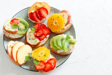 Ricotta peynirli meyve tatlı sandviç. Lezzetli sağlıklı kahvaltı tost ile krem peynir, taze organik meyve ve çilek, otlar, fındık ve arı polen. Diyet sağlıklı yemek, Kahvaltı, snack.