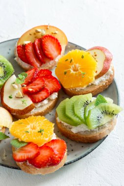 Ricotta peynirli meyve tatlı sandviç. Lezzetli sağlıklı kahvaltı tost ile krem peynir, taze organik meyve ve çilek, otlar, fındık ve arı polen. Diyet sağlıklı yemek, Kahvaltı, snack.