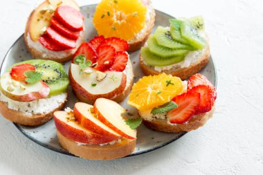 Ricotta peynirli meyve tatlı sandviç. Lezzetli sağlıklı kahvaltı tost ile krem peynir, taze organik meyve ve çilek, otlar, fındık ve arı polen. Diyet sağlıklı yemek, Kahvaltı, snack.