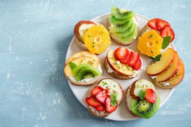 Ricotta peynirli meyve tatlı sandviç. Lezzetli sağlıklı kahvaltı tost ile krem peynir, taze organik meyve ve çilek, otlar, fındık ve arı polen. Diyet sağlıklı yemek, Kahvaltı, snack.