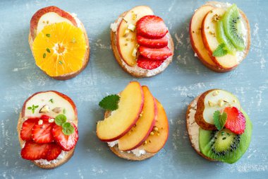 Ricotta peynirli meyve tatlı sandviç. Lezzetli sağlıklı kahvaltı tost ile krem peynir, taze organik meyve ve çilek, otlar, fındık ve arı polen. Diyet sağlıklı yemek, Kahvaltı, snack.