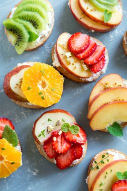 Ricotta peynirli meyve tatlı sandviç. Lezzetli sağlıklı kahvaltı tost ile krem peynir, taze organik meyve ve çilek, otlar, fındık ve arı polen. Diyet sağlıklı yemek, Kahvaltı, snack.