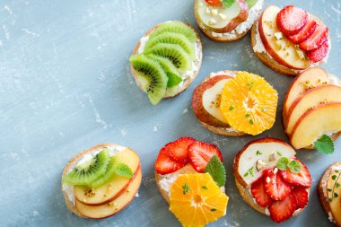 Ricotta peynirli meyve tatlı sandviç. Lezzetli sağlıklı kahvaltı tost ile krem peynir, taze organik meyve ve çilek, otlar, fındık ve arı polen. Diyet sağlıklı yemek, Kahvaltı, snack.