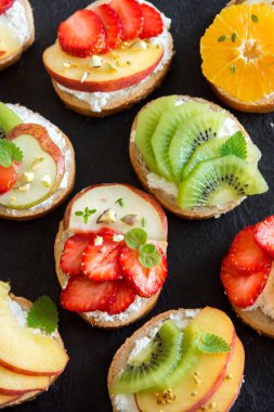 Meyve tatlı sandviç ya da bruschetta ricotta peynirli. Lezzetli sağlıklı kahvaltı tost ile krem peynir, organik meyve ve çilek, otlar, fındık ve arı polen. Diyet sağlıklı yemek, Kahvaltı, snack.