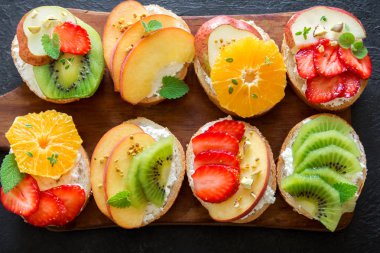 Meyve tatlı sandviç ya da bruschetta ricotta peynirli. Lezzetli sağlıklı kahvaltı tost ile krem peynir, organik meyve ve çilek, otlar, fındık ve arı polen. Diyet sağlıklı yemek, Kahvaltı, snack.