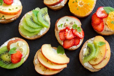 Meyve tatlı sandviç ya da bruschetta ricotta peynirli. Lezzetli sağlıklı kahvaltı tost ile krem peynir, organik meyve ve çilek, otlar, fındık ve arı polen. Diyet sağlıklı yemek, Kahvaltı, snack.